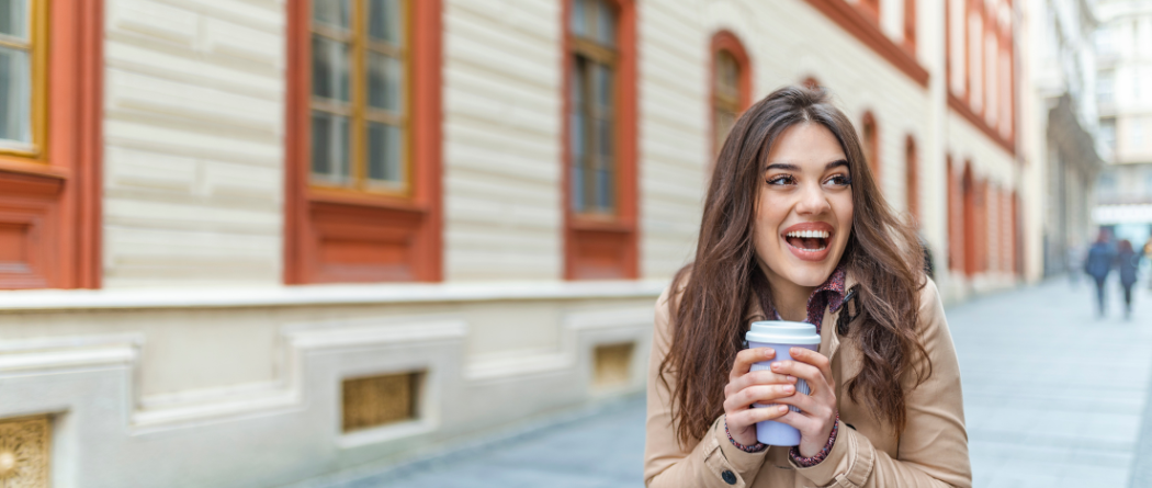woman holding coffee smiling