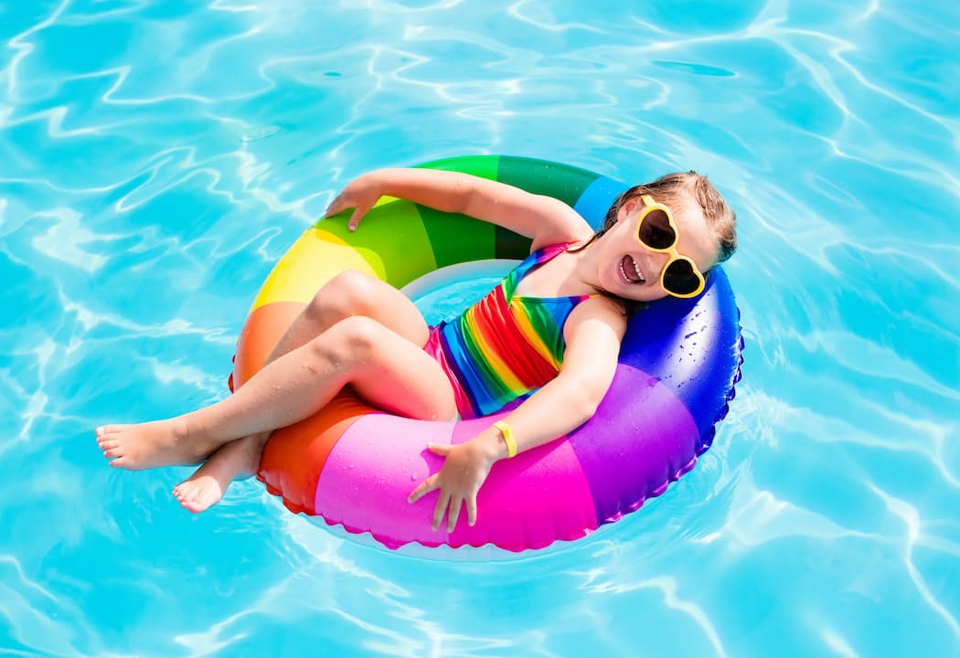 little girl on colorful swimming pool float
